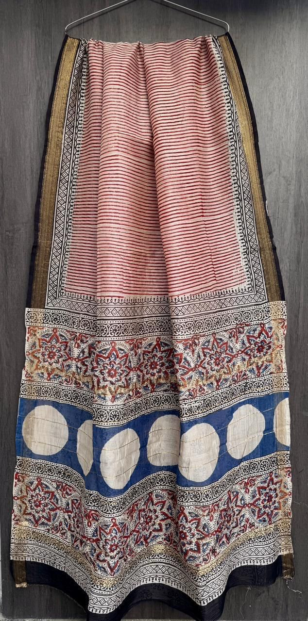 red and white hand-block printed Maheshwari or Chanderi silk/cotton blend saree with traditional motifs, blue circular appliques, and a red and gold zari border.