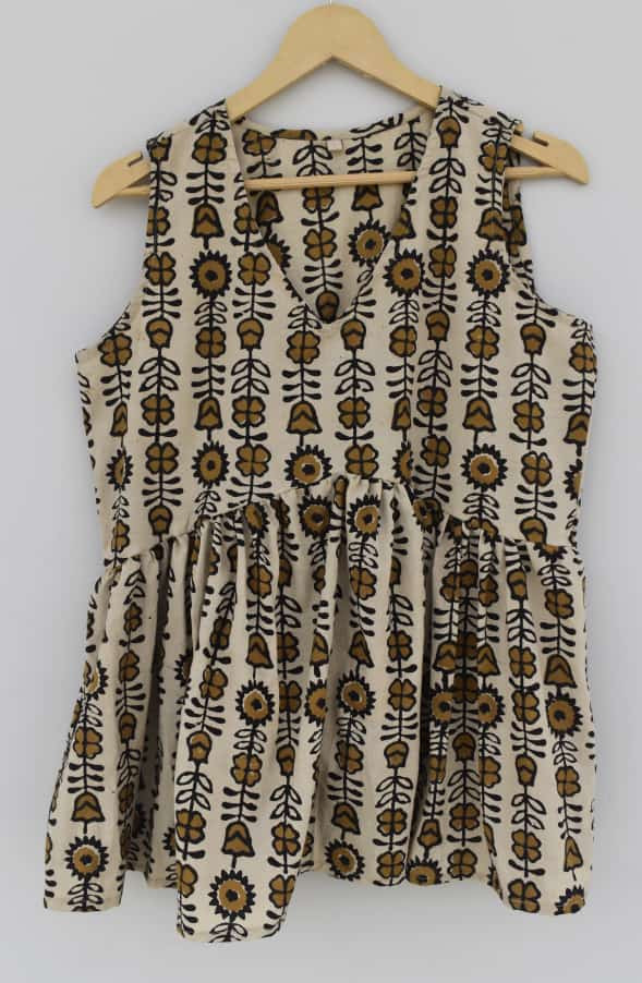 beige, black, and mustard yellow hand-block printed, floral and leaf pattern cotton sleeveless peplum top